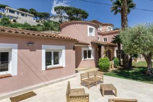 a pink house with chairs and a patio at Villa de Luxe à Begur Vue Mer in Begur