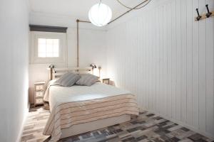a bedroom with a bed in a white room at Las Sales Estudio in Moya