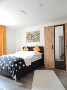 a bedroom with a black and white bed and a mirror at Karins Pension in Lampertheim