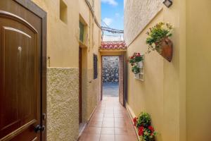 an alley way with flowers on the walls and a door at Las Sales Estudio in Moya
