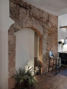 a room with a stone wall and a table and a chair at Appartamento Luxury - Torre in Terracina +18 photos