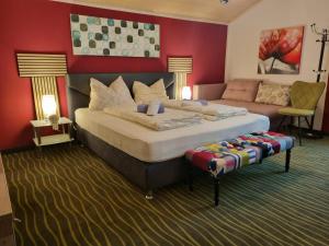 a bedroom with a large bed and a couch at Simply Rooms in Velden am Wörthersee