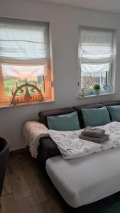 a bedroom with a bed and two windows at Ferienwohnung Strandliebe in Lubmin