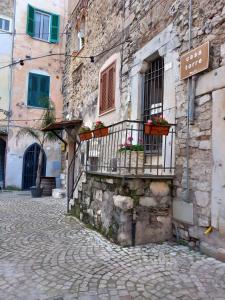 a stone building with flower boxes on a balcony at Appartamento Luxury - Torre in Terracina