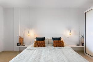 a white bedroom with a large white bed with pillows at Apartamento Erma Candelaria in Candelaria +17 photos