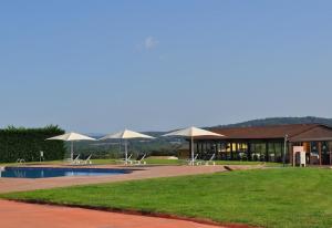 a building with chairs and umbrellas and a pool at luxury stone villa in Girona