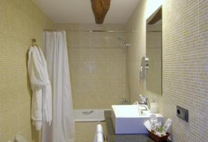 a bathroom with a white shower curtain and a sink at luxury stone villa in Girona +14 photos