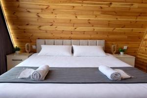 a bedroom with a bed with two towels on it at A-frame evlər-II in Qusar +17 photos
