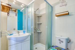 a bathroom with a sink and a shower at Les Ptits Loups, le Grau d'Agde in Le Grau-dʼAgde