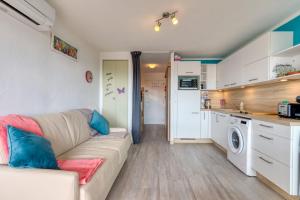 a living room with a couch and a kitchen at Les Ptits Loups, le Grau d'Agde in Le Grau-dʼAgde +15 photos