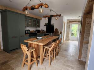 a kitchen with a wooden table and some chairs at Le Gite du Bois Renard in Lorigné