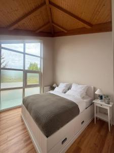 a bedroom with a large bed and a large window at Küstenloft-Leuchturm in Rostock