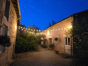 an alley with lights on the side of buildings at night at Le Gite du Bois Renard in Lorigné