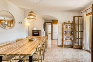 a kitchen and dining room with a wooden table and chairs at Castell Mirto - villa private pool in Calonge