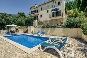 a swimming pool with lounge chairs and a building at Castell Mirto - villa private pool in Calonge