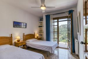 a bedroom with two beds and a sliding glass door at Castell Mirto - villa private pool in Calonge +17 photos