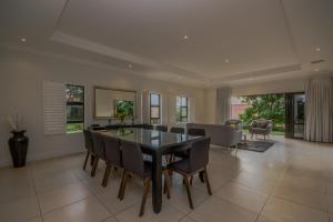 a dining room with a glass table and chairs at 8 Tinderwood Lane in Ballito