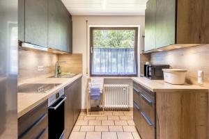a kitchen with wooden cabinets and a window at B463 Penthouse in Albstadt