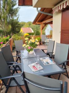 a table and chairs on a patio with flowers at Chambres D'hôtes - Suite Pampas in Geiswiller
