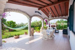 an outdoor patio with a table and chairs at Villa Funtana Cortese in Orosei