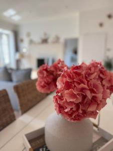 a white vase with pink flowers in a living room at Détente et vue exceptionnelle à L'appart' de Charles in Dole