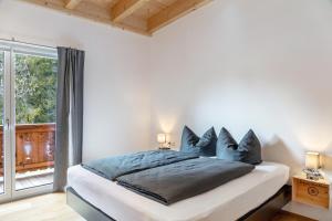 a white bedroom with a bed with blue pillows at Apartment Lorenz in Scharnitz