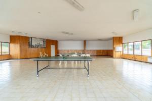 a ping pong table in the middle of a room at Maison 6 Pers, proche de la plage in Vendres