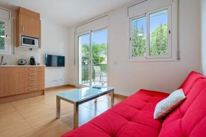 a living room with a red couch and a table at Dorada Apartment Lluna in Calafell