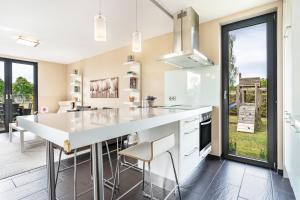 a kitchen with a large white island with stools at Nova Ferienhaus, 50qm in Ueckermünde