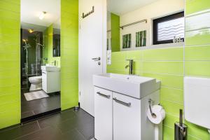 a green bathroom with a sink and a toilet at Nova Ferienhaus, 50qm in Ueckermünde +28 photos