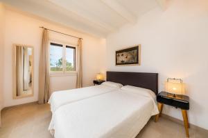 a white bedroom with a large bed and a window at Es Pinaró Sansó in Artá +26 photos
