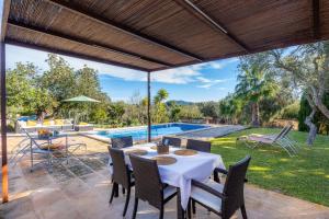 a patio with a table and chairs and a pool at Es Pinaró Sansó in Artá