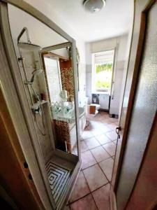 a bathroom with a shower and a large mirror at Casa Lù in Abbadia Lariana