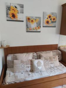a couch with pillows and pictures on the wall at Casa Lù in Abbadia Lariana