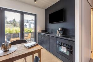 a kitchen with a table and a tv on a wall at Apartment Schlossterrassen 4a in Pouch