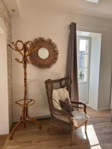 a wicker chair and a mirror in a room at Détente et vue exceptionnelle à L'appart' de Charles in Dole