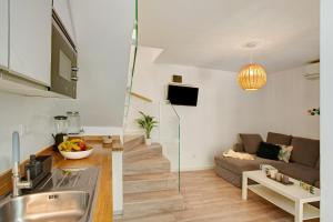 a kitchen and living room with a couch and a table at Bungalow Sonemar Sunshine in Maspalomas