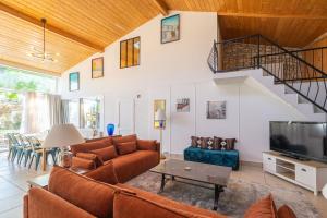 a living room with a couch and a tv at Les gîtes du logis in Saint-Romain-de-Benet