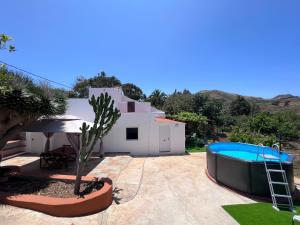 a villa with a swimming pool and a house at Villa Almagre in Gáldar