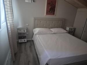 a bedroom with a white bed and two night stands at Piccolo Chalet Comfort E Stile in Marotta