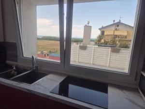 a kitchen counter with a sink and two windows at Piccolo Chalet Comfort E Stile in Marotta +20 photos