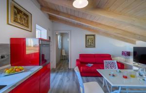 a kitchen and living room with red cabinets and a red couch at Piccolo Chalet Comfort E Stile in Marotta
