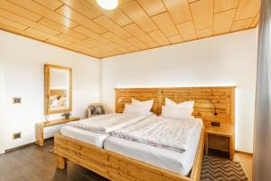 a bedroom with a large bed with a wooden headboard at Chalet Am Scheidt in Medebach