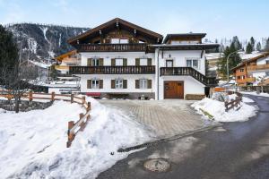 a large house with snow in front of it at Ciasa Christina in Moena