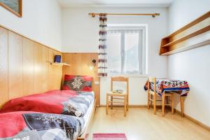 a small bedroom with a bed and a window at Ciasa Christina in Moena