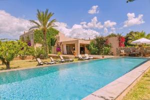 a swimming pool with chairs and a house at Son Puca 1 in Búger