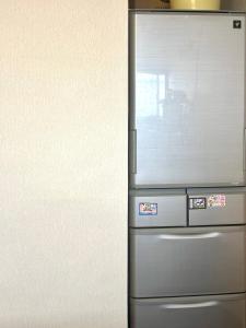 a stainless steel refrigerator with a window in a kitchen at 明月民宿 in Takatsuki