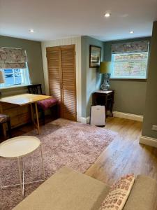 a living room with a table and chairs and a table at The Grannery in Wadhurst +24 photos