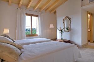 a white bedroom with two beds and a mirror at Son Puca 1 in Búger +23 photos