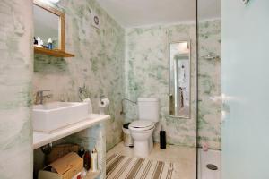a bathroom with a sink toilet and a mirror at Sira Stonehouse l in Volímai